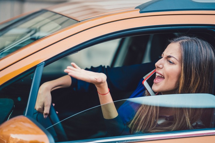 Furious woman stucked in traffic jam Poor road etiquette and losing money among the average Briton's biggest gripes, study finds