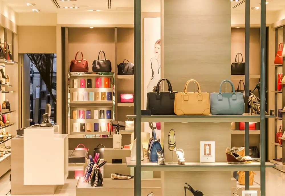 Modern retail store displaying handbags and accessories in a well-lit showroom.