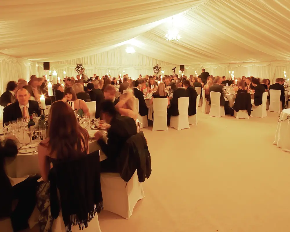 Warmly lit marquee interior with dining tables