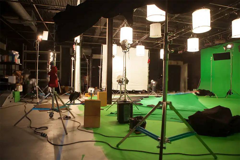 A large warehouse-style film production sound stage with green screens and overhead lighting, typical of the vast volumes heated by the Aurora FH 2000S.