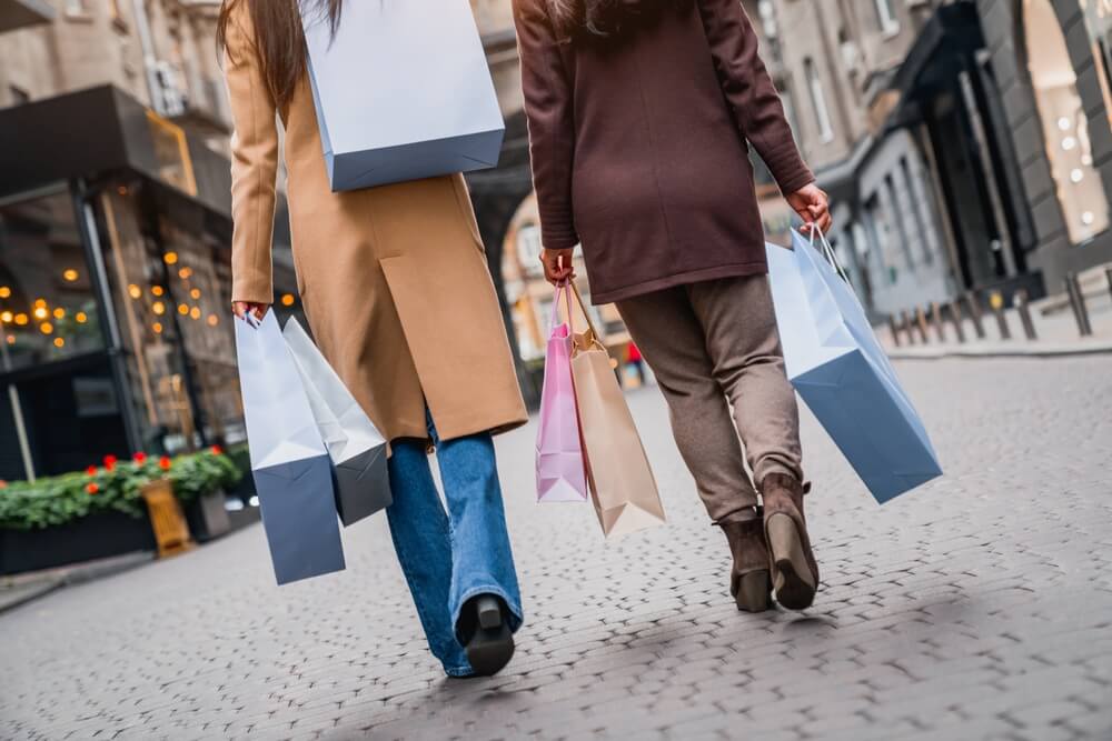 Female shoppers browsing retail store during summer heatwave – highlighting customer comfort needs in UK high street shops